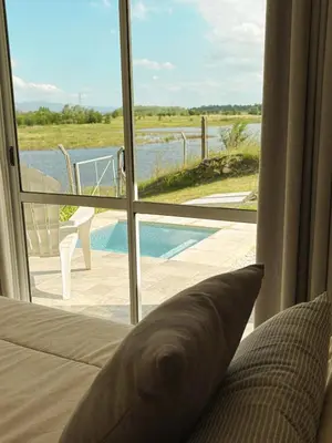 a bedroom with a bed and a view of a pool at Cabañas Titina's Lake in Potrero de Garay