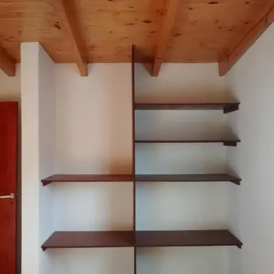 a book shelf in a room with wooden ceilings at Departamento Estancia Vieja 74 PA in Estancia Vieja