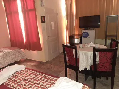 a room with a table and chairs and a television at Complejo Mirador de las Sierras pileta climatizada al aire libre in San Javier