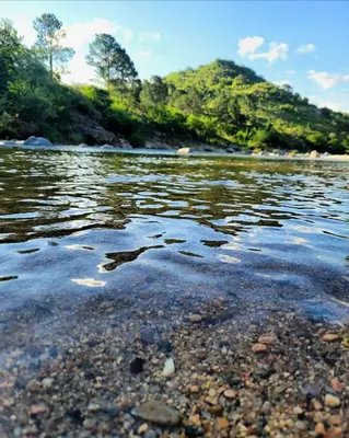 a body of water with rocks and trees in the background at Casa Filomena in Villa Canada del Sauce