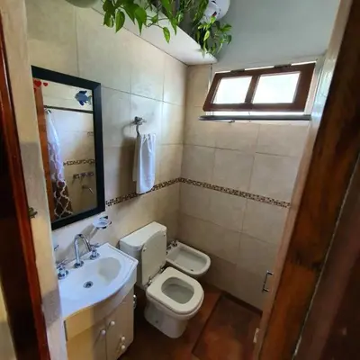 a bathroom with a toilet and a sink and a window at Casa Filomena in Villa Canada del Sauce