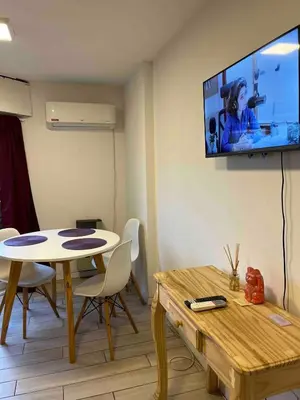 a living room with a table and a tv on the wall at Hermoso departamento en el centro de Cordoba, somos ApartamentosCordoba in Cordoba