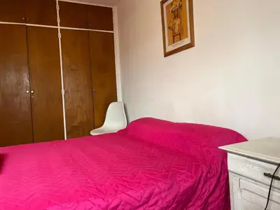 a bedroom with a bed with a red bedspread at Hermoso departamento en el centro de Cordoba, somos ApartamentosCordoba in Cordoba