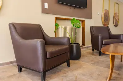 a waiting room with two leather chairs and a table at Wooden Hotel in Villa Carlos Paz