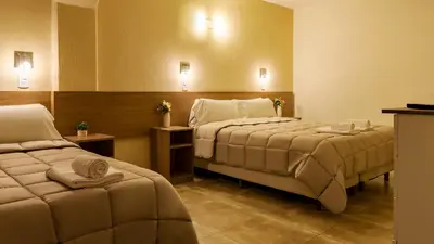 a hotel room with two beds with towels on them at Wooden Hotel in Villa Carlos Paz