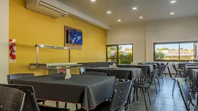 a dining room with tables and chairs and yellow walls at Wooden Hotel in Villa Carlos Paz