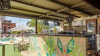 a restaurant with a colorful counter with a pool at Wooden Hotel in Villa Carlos Paz