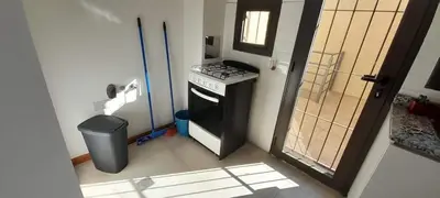 a kitchen with a stove and a trash can at Aparts Kodu- Residencia Familiar in Río Cuarto