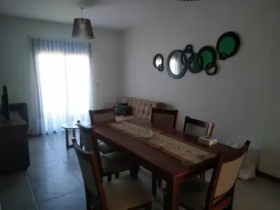 a dining room with a table and some mirrors on the wall at Aparts Kodu- Residencia Familiar in Río Cuarto