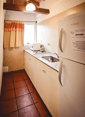 a small kitchen with a sink and a refrigerator at La Candida departamentos in Merlo
