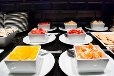 a table topped with white plates and bowls of fruit at THE HOTEL in Cordoba
