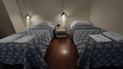a room with two beds and a table between them at THE HOTEL in Cordoba