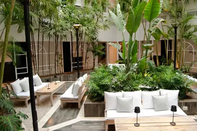 a lobby with white couches and palm trees at THE HOTEL in Cordoba