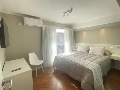 a bedroom with a bed and a desk and a window at DEPARTAMENTO CENTRICO CON COCHERA - CORDOBA Argentina- in Cordoba
