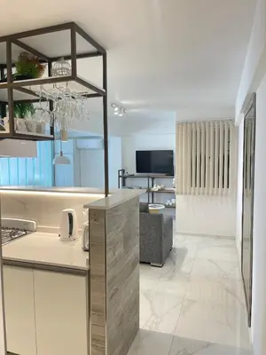 a kitchen with a counter and a living room at DEPARTAMENTO CENTRICO CON COCHERA - CORDOBA Argentina- in Cordoba
