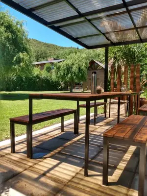 a picnic table and benches on a patio at Balcón de la montaña in Santa Rosa de Calamuchita