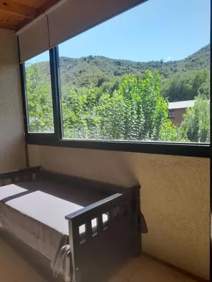 a bedroom with a bed and a large window at Balcón de la montaña in Santa Rosa de Calamuchita