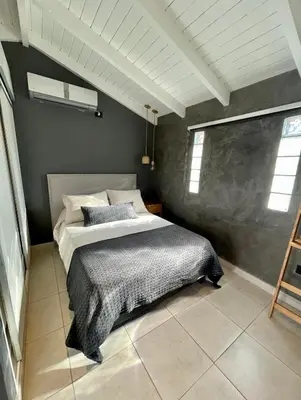 a bedroom with a bed with a gray wall at Loft 2023 in Villa Carlos Paz