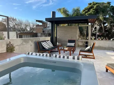 a swimming pool in a backyard with chairs and a table at Loft 2023 in Villa Carlos Paz