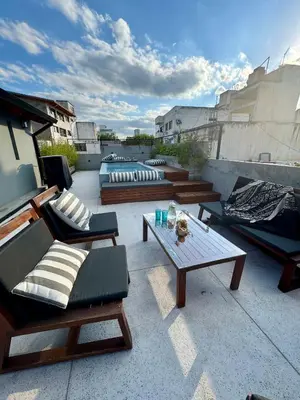 a patio with couches and tables on a rooftop at Loft 2023 in Villa Carlos Paz