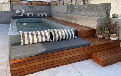 a hot tub sitting on a wooden deck with pillows at Loft 2023 in Villa Carlos Paz