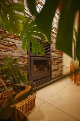 a fireplace in a living room with a stone wall at El Nogal Apart Hotel in Villa General Belgrano