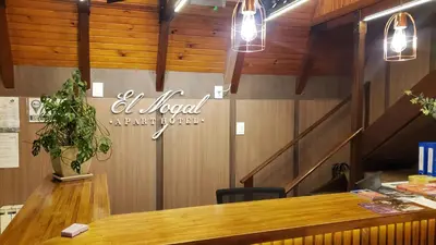 a restaurant with a table and a sign on the wall at El Nogal Apart Hotel in Villa General Belgrano
