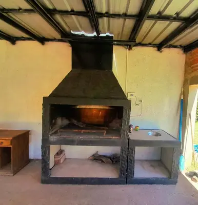 an old stove in a room with a table at Casa el sueño de Alicia in Villa del Dique