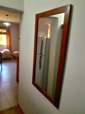 a mirror on a wall with a refrigerator in a room at Casa el sueño de Alicia in Villa del Dique