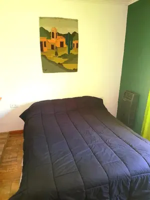 a bed in a bedroom with a painting on the wall at Casa el sueño de Alicia in Villa del Dique