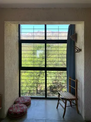 a room with a large window with a bench and a chair at La Molicie, Achiras Arriba in San Javier