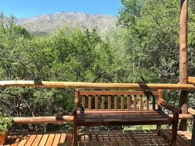 a wooden bench sitting on a deck with a view at La Molicie, Achiras Arriba in San Javier