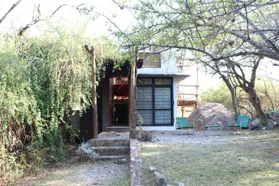 a house with two green benches in front of it at La Molicie, Achiras Arriba in San Javier