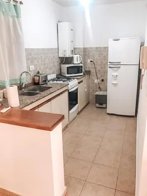 a kitchen with a white refrigerator and a tile floor at Departamento en la mejor zona de GENERAL PAZ in Cordoba