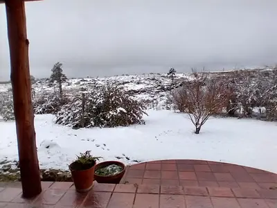 a patio with snow on the ground and plants at Herencia Nativa in Villa Yacanto