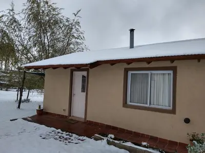 a house with a white door in the snow at Herencia Nativa in Villa Yacanto