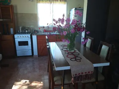 a kitchen with a table with a vase of flowers on it at Herencia Nativa in Villa Yacanto