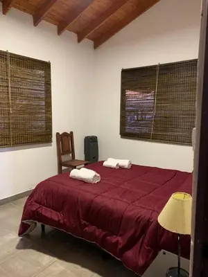 a bedroom with a red bed with two towels on it at MORADA DEL ZORRO in Merlo