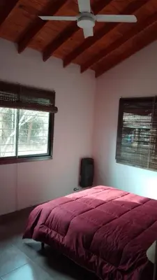a bedroom with a red bed and a ceiling fan at MORADA DEL ZORRO in Merlo