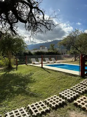 a swimming pool with lounge chairs in the grass at MORADA DEL ZORRO in Merlo