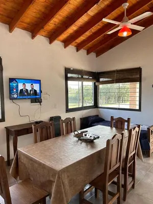 a dining room with a table and chairs and a tv at MORADA DEL ZORRO in Merlo