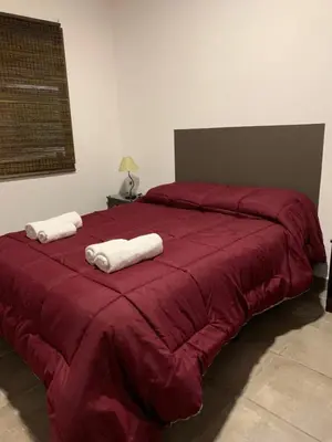 a red bed with two towels on top of it at MORADA DEL ZORRO in Merlo