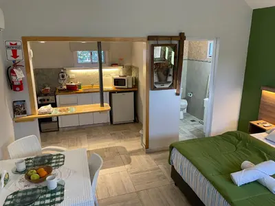 a living room with a couch and a table and a kitchen at CasitaLiu in Villa General Belgrano