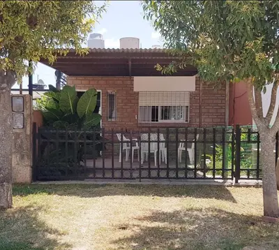 a fence in front of a house with chairs at Lo de Liliana in Tanti