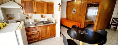 two pictures of a kitchen with a table and a room at Lo de Liliana in Tanti
