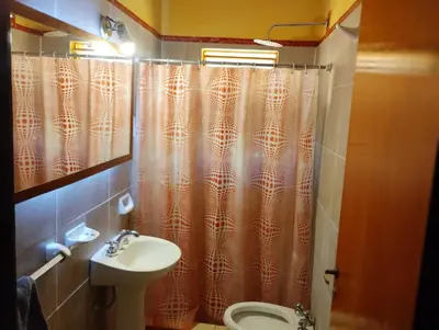 a bathroom with a shower curtain and a sink at Cabañas Don Pocho in Villa Cura Brochero