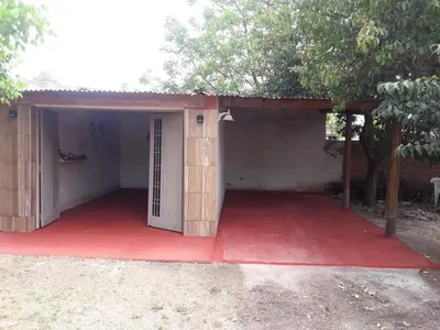 a small house with a red floor and a door at Cabañas Don Pocho in Villa Cura Brochero