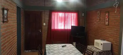 a room with a red window and a table with a microwave at Cabañas Don Pocho in Villa Cura Brochero