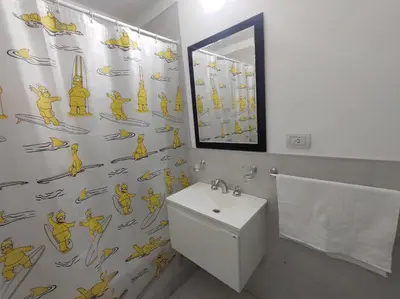 a bathroom with a shower curtain with a toilet and a sink at ALTOS DE CLERMONT in Cordoba