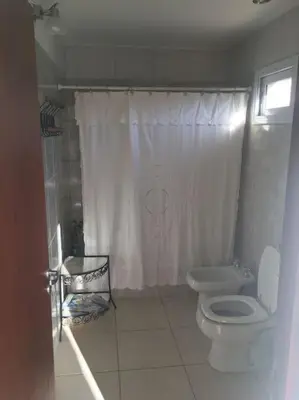 a bathroom with a white toilet and a shower at Arcángeles del Oeste - Descanso al pie de la montaña in La Población